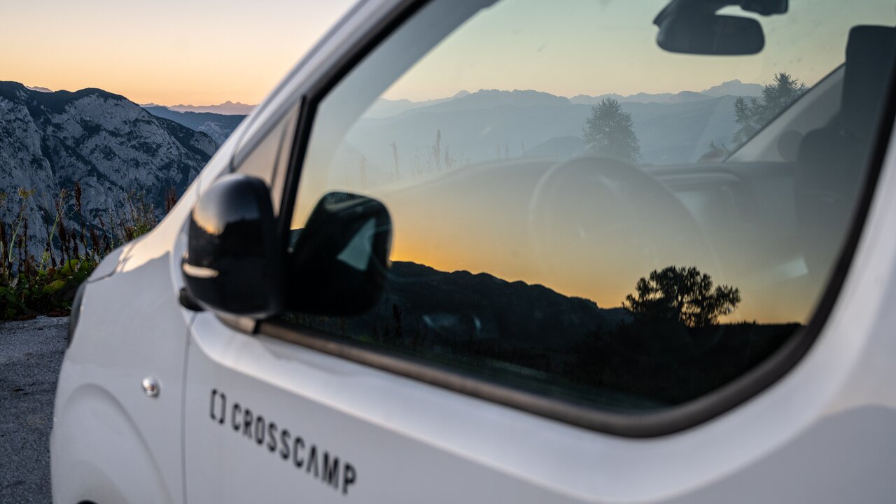 Österreichische Bergwelt gespiegelt im Camper Van Fenster