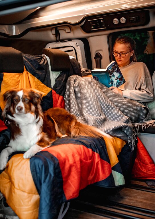 Carly Eck mit ihrem Hund im gemütlichen Innenraum des CROSSCAMP