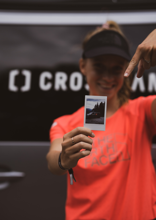 Trailrunnerin Ida-Sophie Hegemann hält Polaroid mit sich und dem CROSSCAMP vor die Kamera