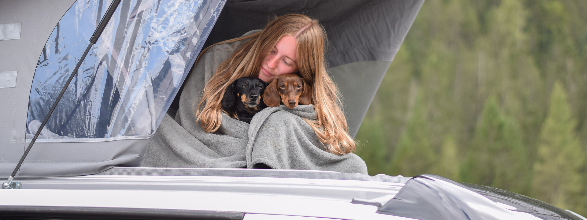 Jania mit ihren beiden Hunden im Hochdach des CROSSCAMP BASE X