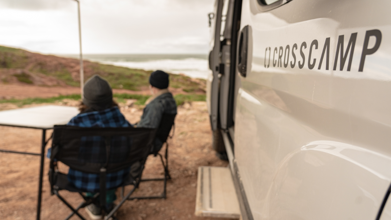 Vater und Sohn blicken auf das portugiesische Meer unter Vorzelt des CROSSCAMP FLEX541