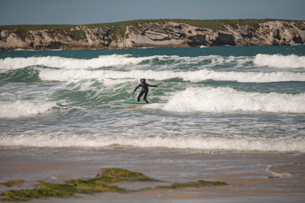 Sohn surft Wellen in Portugal