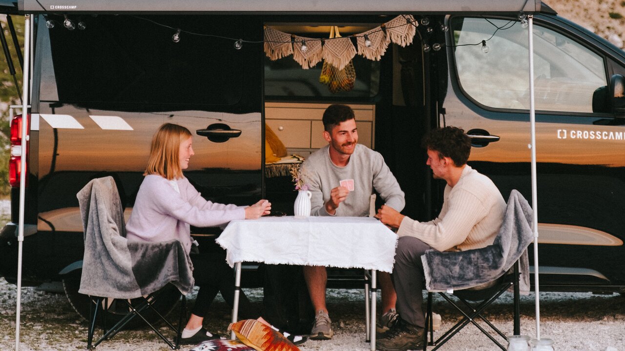 Freunde sitzen vor CROSSCAMP in Slowenien beim Campen