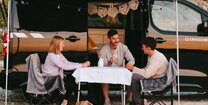 Freunde sitzen vor CROSSCAMP in Slowenien beim Campen
