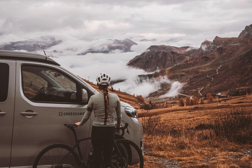 Alina Jäger steht mit ihrem Rennrad in den Dolomiten vor dem CROSSCAMP