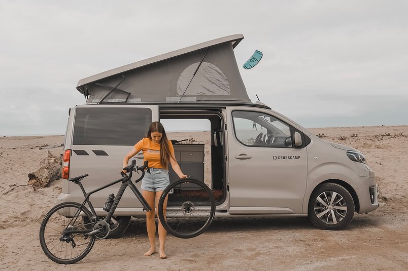 Alina Jäger steht mit ihrem Rennrad in den Dolomiten vor dem CROSSCAMP